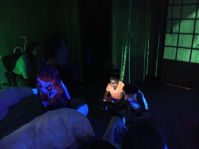 Glow in the dark story telling with Kids Corps members and people served.